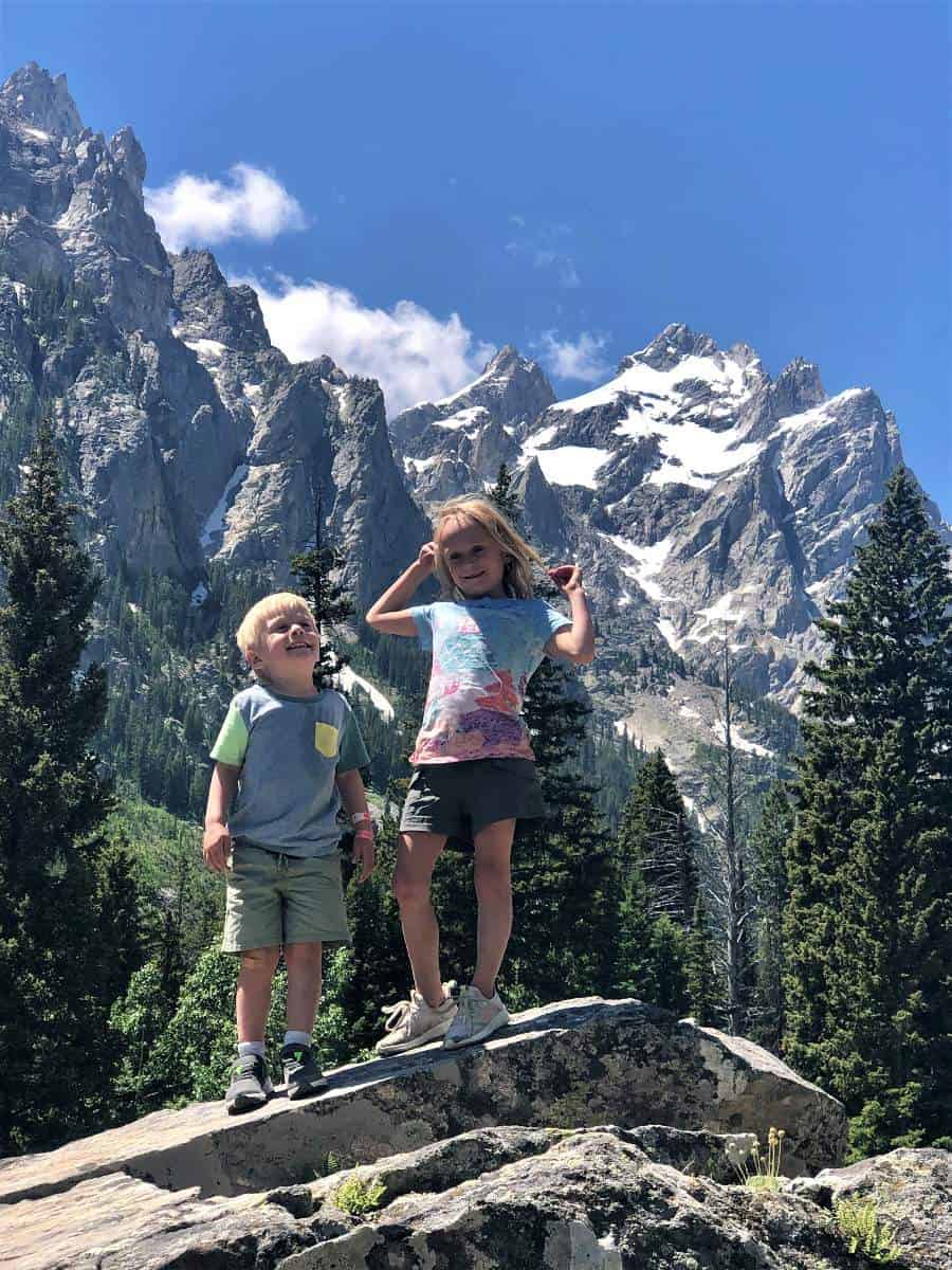 Kids standing in front of Grand Tetons on Inspiration Point hike