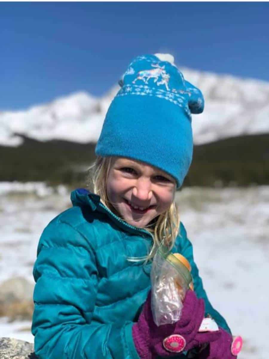 What to pack for snacks on a hike - Girl eating sandwich on hike in Colorado