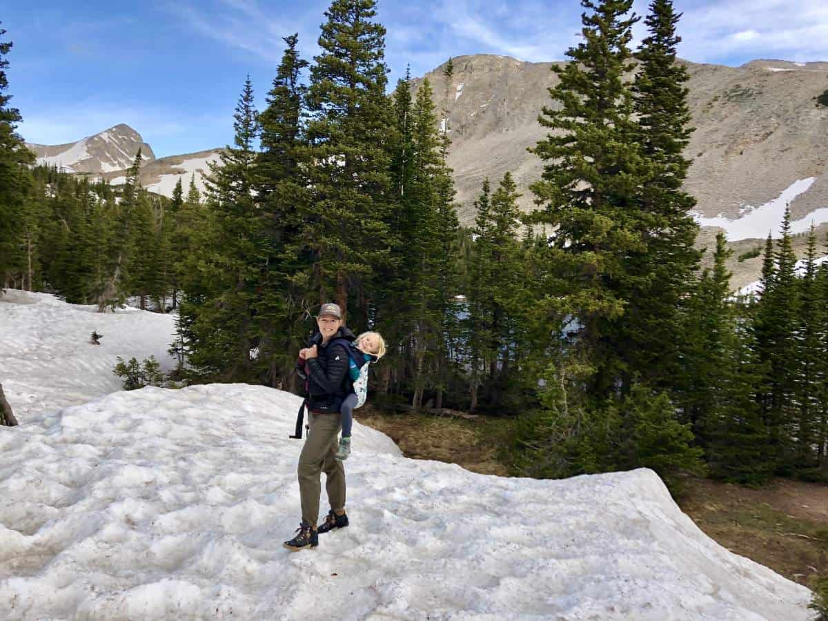 What to pack - Mom carrying child in back carrier on a snowy hike in Colorado