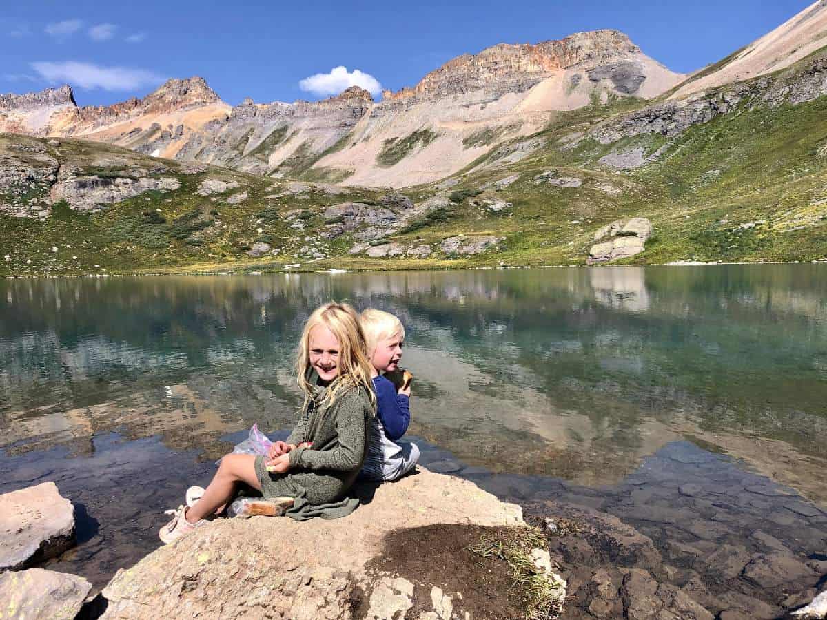 What to pack for snacks on a hike - Kids eating lunch at Ice Lake in Colorado