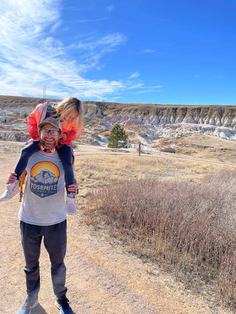 Daughter on dad's shoulders at Paint Mines hike