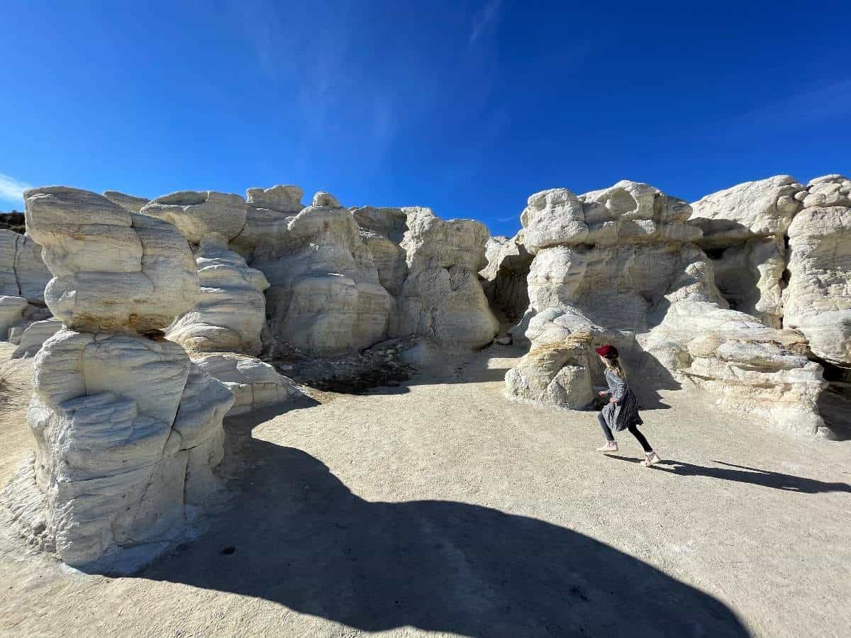 Girl running in front of white sandstone in Paint Mines Colorado