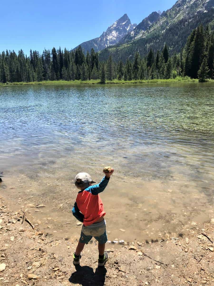 Boy throwing rock into String Lake in Grand Teton National Park