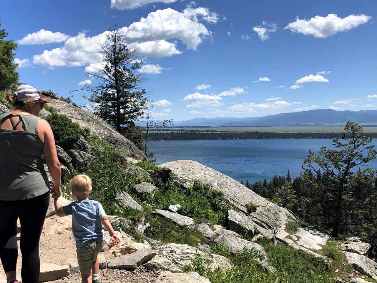 Mom and son hiking with Jenny Lake in front 