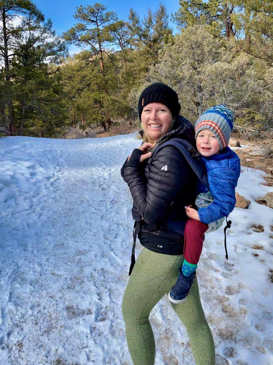 Mom carrying child in a hiking backpack