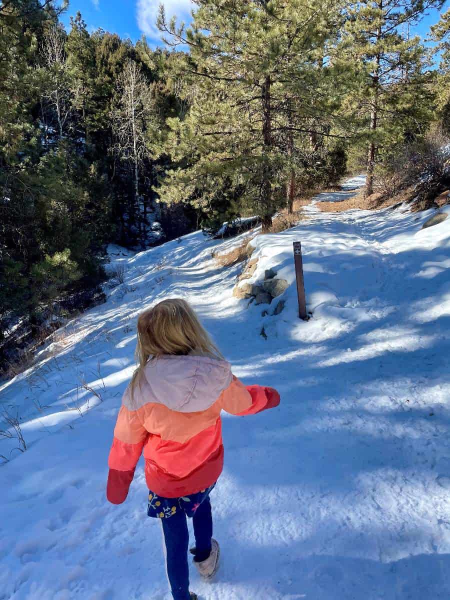 Girl pointing to trail sign on Denver kid hike