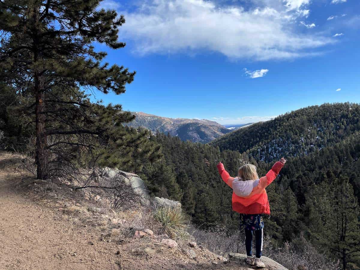 Girl with arms outstretched on Denver Kid hike looking at the view