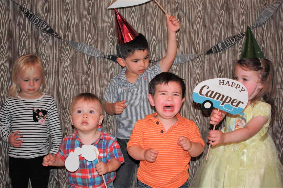 Boy crying in group of kids in photo booth