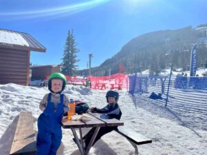 Kids taking a lunch break on their first time skiing