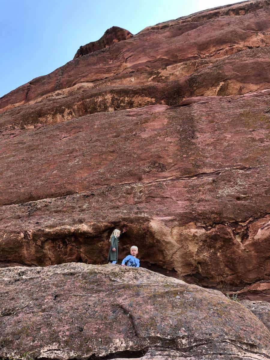 kids in front of red rock wall on hike