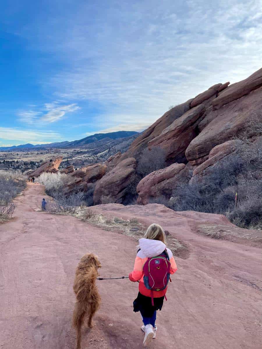 Girl and dog hiking on red rocks