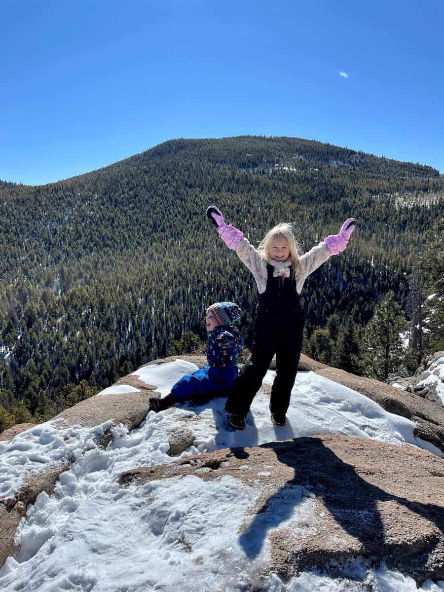 Girl with arms up at top of the hike