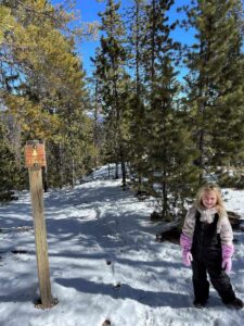 girl standing at trail sign