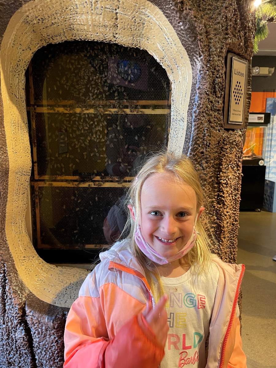 girl in front of beehive
