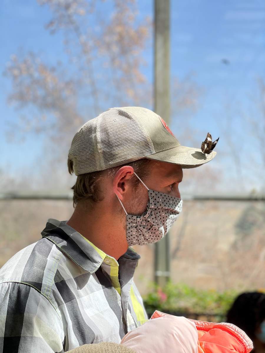 man with butterfly on hat