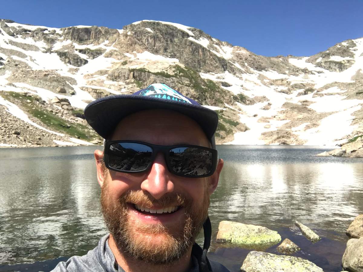 man at lake on wildflower hike