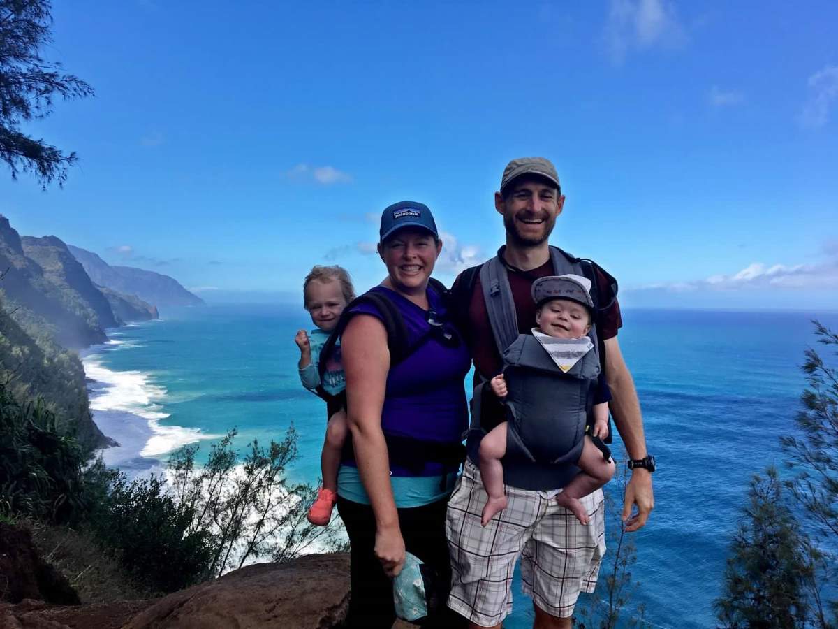 Parents carrying kids on hike in Hawaii