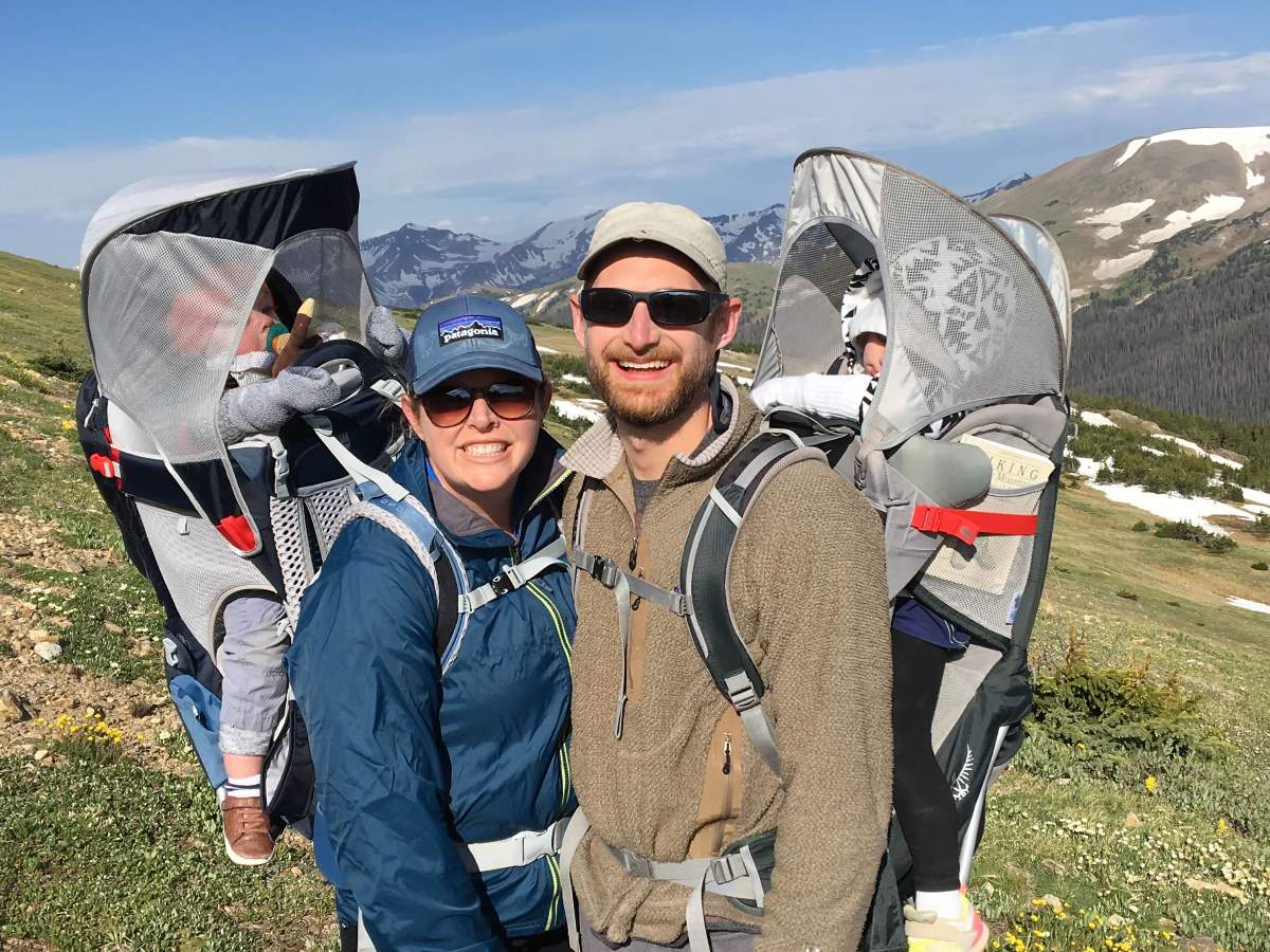 parents carrying kids in hiking carriers