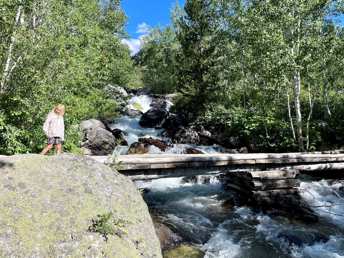 Girl crossing creek on Taggart Lake Hike