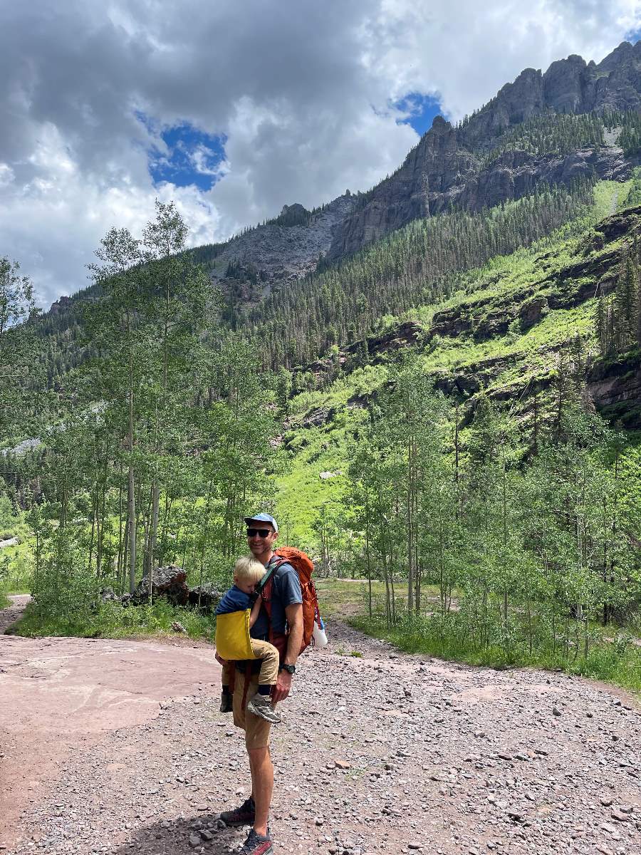 Dad carrying child in Trail Magik carrier