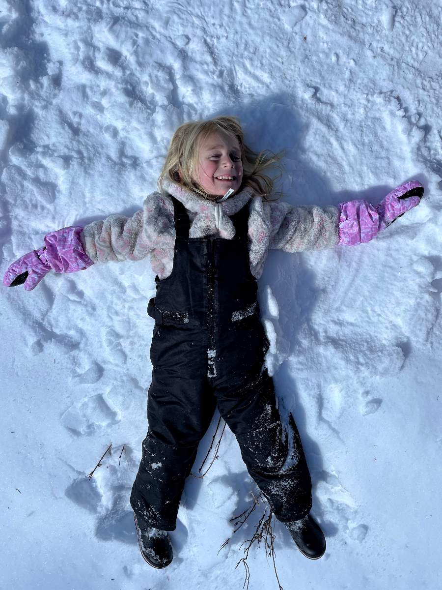 girl making snow angel