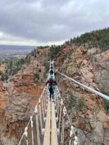 women crossing suspension bridge