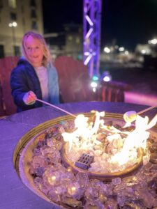 girl roasting marshmallows by the fire at Winterfest