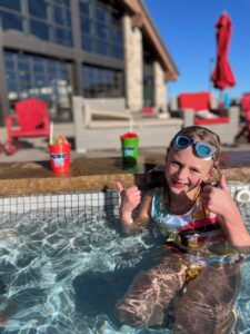 girl in pool with Kona Ice