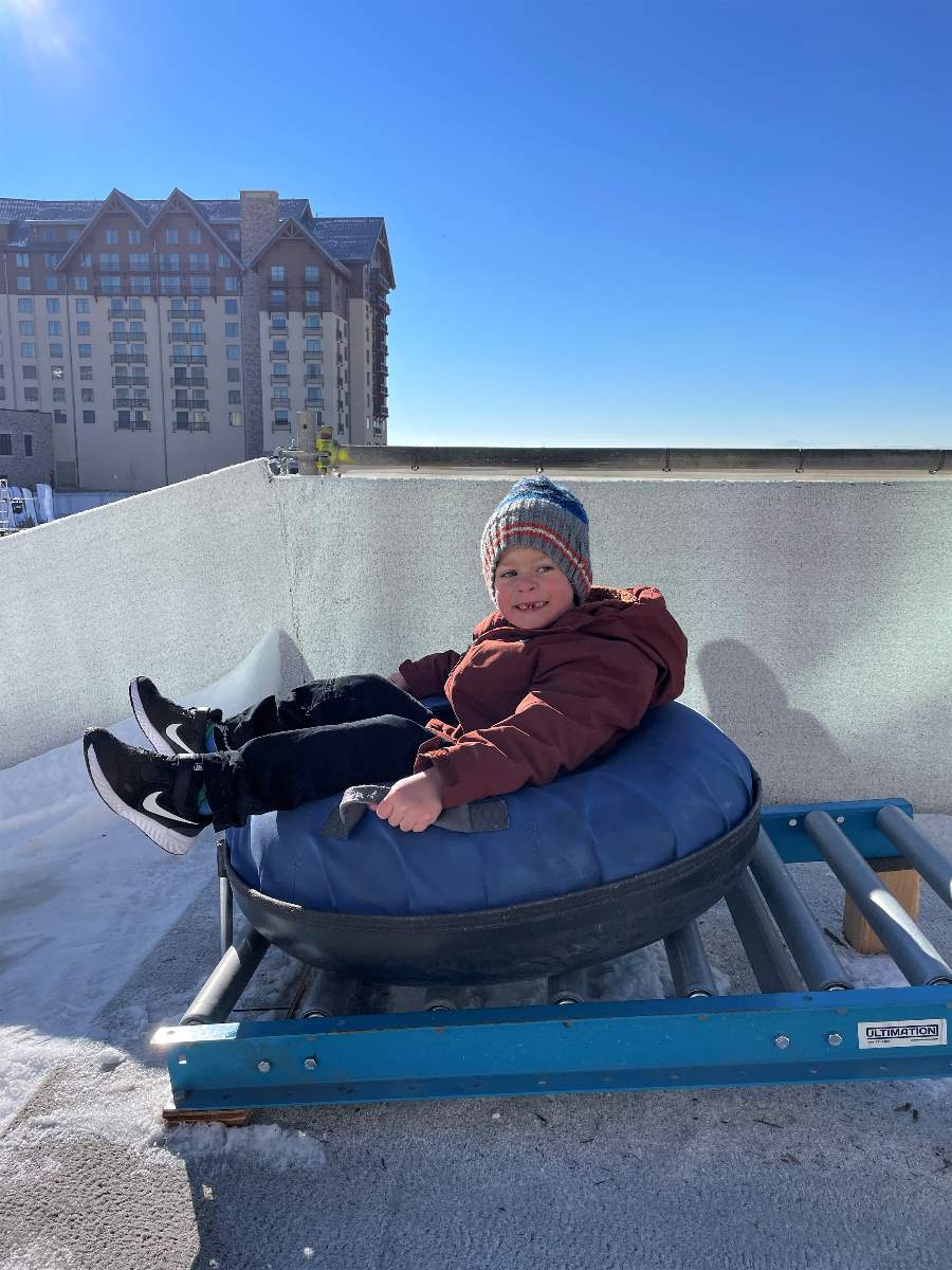 boy on snow tubing hill