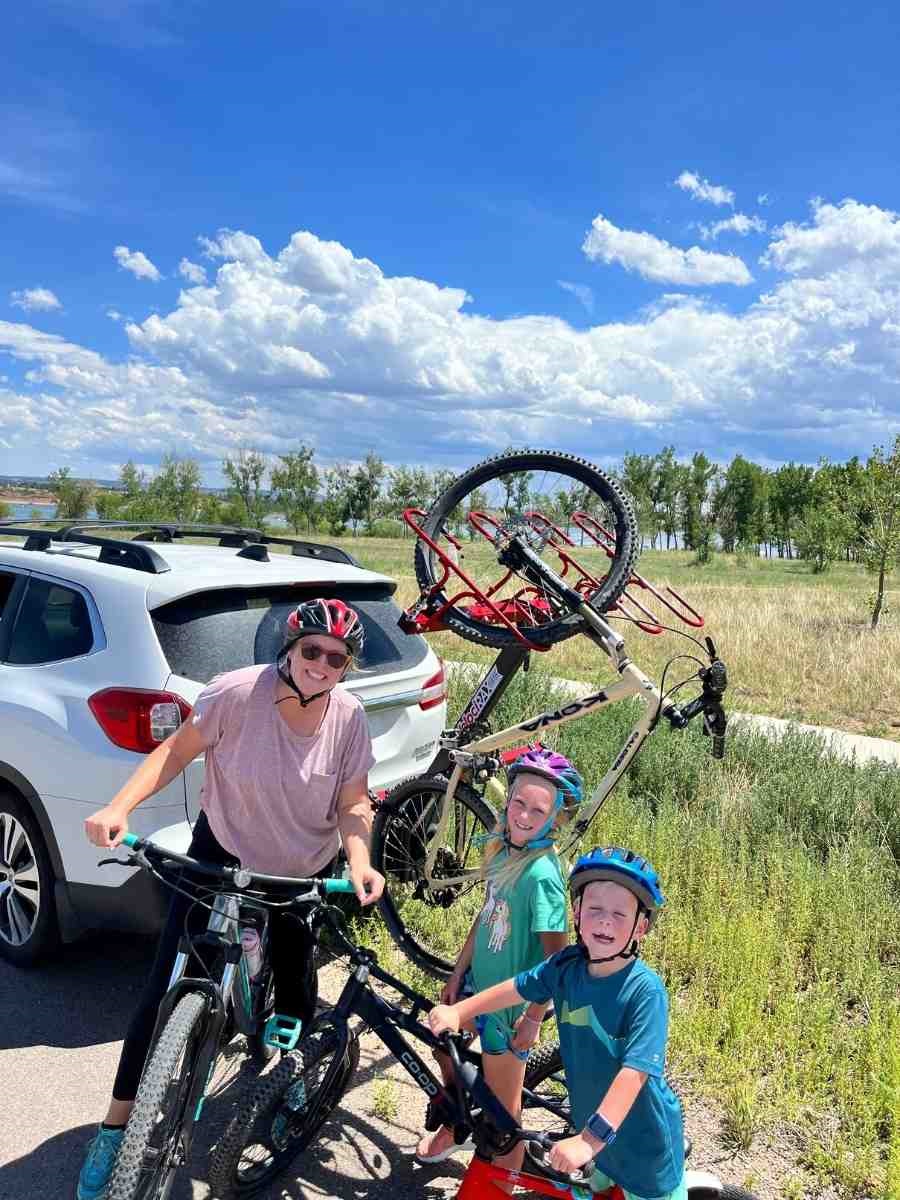 Mom with kids, bikes and bike rack. 