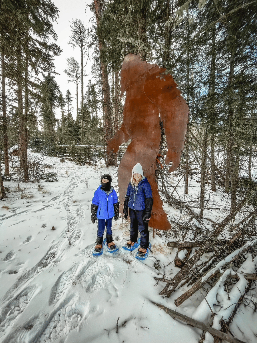 Kids in front of Sasquatch cut out snowshoeing