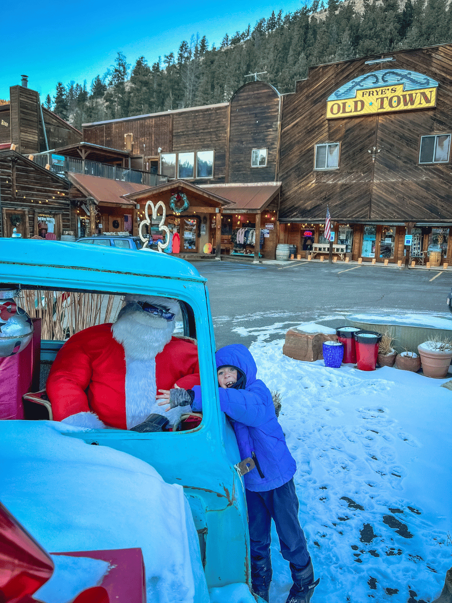 Boy with Santa in old car on Main Street in Red River