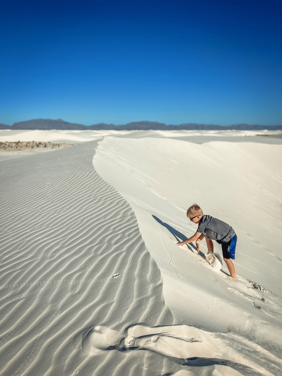 Kid hiking up sand dune in White Sands National Park