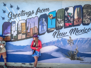 Kids standing in front of Greetings from Alamogordo, New Mexico sign
