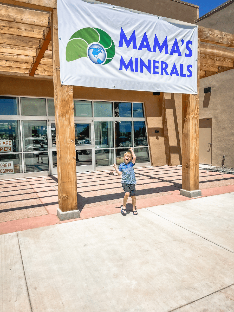 Boy in front of Mama's Minerals sign