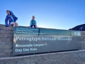 Kids on the Petroglyph National Monument sign