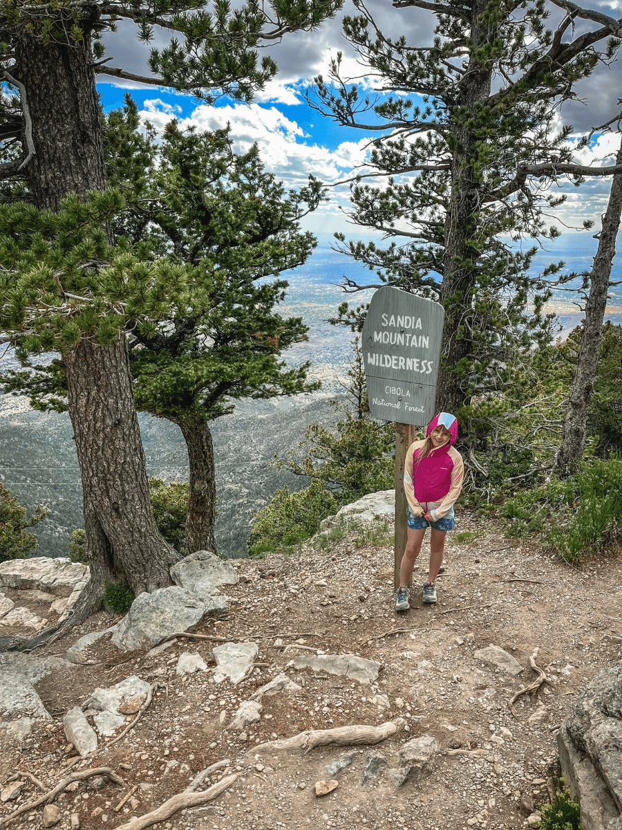 Girl in front of Sandia Mountain Wilderness sign